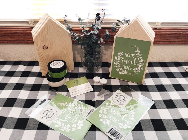 May include: A craft project with two unfinished wooden houses, a green sign that says "Home Sweet Home", and two stencils that say "Home Sweet Home".