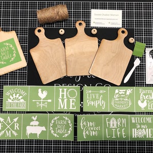May include: A set of farmhouse-themed craft supplies including three wooden cutting boards, stencils with phrases like "Farm to Table", "Welcome to the Farm", and "Farm Life", and a jar of white paint.
