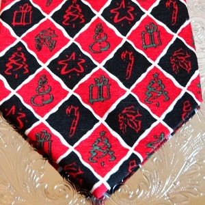 May include: A red and black patterned tie with a diamond pattern featuring Christmas-themed symbols like presents, candy canes, stars, and Christmas trees.