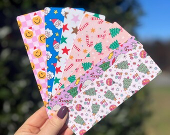 May include: A set of eight Christmas-themed bookmarks with various designs, including Santa Claus, candy canes, Christmas trees, and the words "Ho Ho Ho".