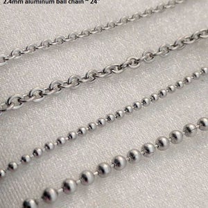 May include: Close-up of four different stainless steel and aluminum chains. The chains include a 2mm stainless steel chain, a 2.5mm stainless steel chain, a 1.5mm stainless steel ball chain, and a 2.4mm aluminum ball chain. The chains are available in various lengths, including 18, 20, 22, and 24 inches.