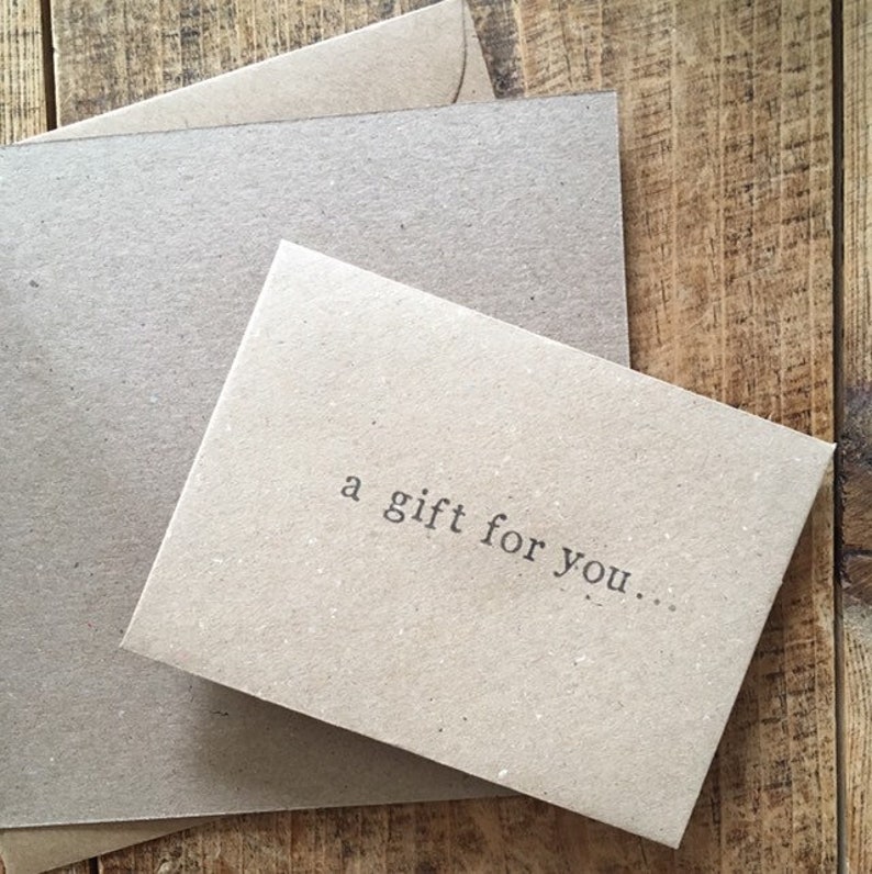 K&ouml;nnte beinhalten: Eine braune Karte mit dem Text "a gift for you..." darauf gedruckt.