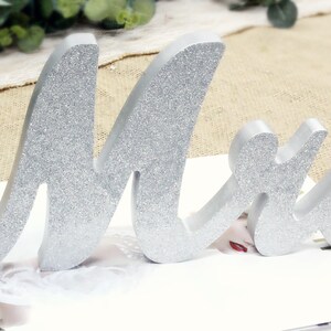 Peut inclure: Un panneau en bois avec des paillettes argent&eacute;es "Mme" pour un mariage ou une f&ecirc;te de fian&ccedil;ailles. Le panneau est en bois et a une police cursive.