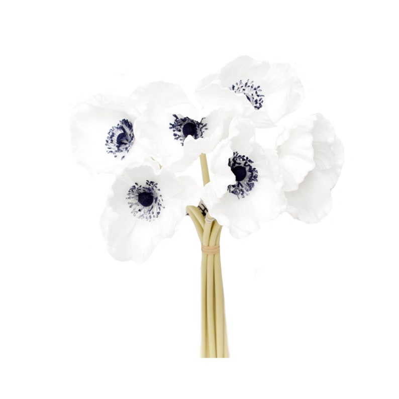 May include: A bouquet of white artificial anemones with dark blue centers. The flowers are tied together with a brown ribbon.