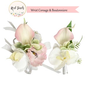May include: A white and pink wrist corsage and boutonniere with calla lilies, orchids, and greenery. The corsage has a pearl bracelet.