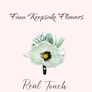 May include: Faux keepsake flowers in a white and green color scheme. The flowers are made to look like real flowers and have a realistic touch. The flowers are arranged in a bouquet and are attached to a black stem.