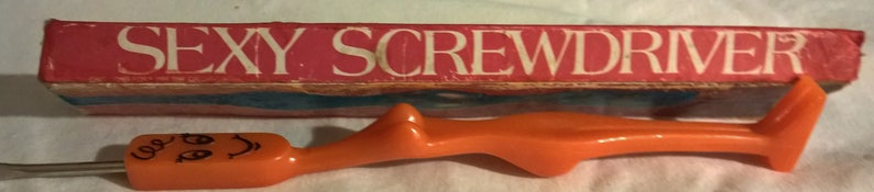 May include: An orange screwdriver with a cartoon face drawn on the handle, next to a red box with the words "SEXY SCREWDRIVER" in white. The screwdriver has a unique, curvy design.