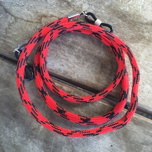 May include: Red and black patterned eyeglass cord or strap with silver metal clasps.