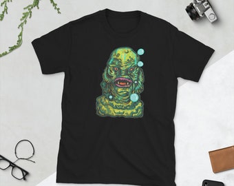 May include: Black t-shirt with a green and blue illustration of the Creature from the Black Lagoon. The creature is surrounded by bubbles.
