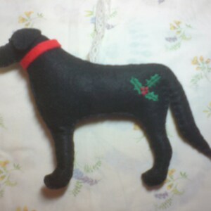 May include: Black felt dog ornament with a red collar and green holly embroidery.