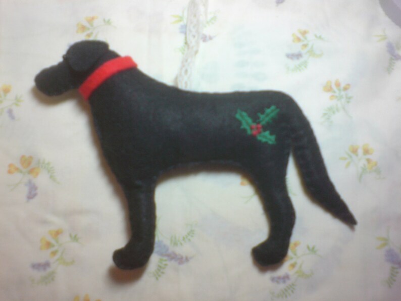 May include: Black felt dog ornament with a red collar and green holly embroidery.