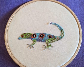 Hand embroidered Union Island Gecko wall hanging picture, beechwood hoop display frame