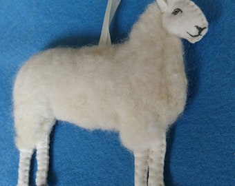 May include: A white felt sheep ornament with black hooves and a white ribbon for hanging.