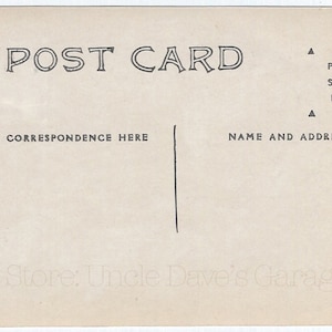 以下が含まれることがあります： 上部に「POST CARD」という文字が印刷されたビンテージのポストカード。カードの裏面には、宛先の住所と差出人の名前と住所を記入するスペースがあります。右上に「PLACE STAMP HERE」という文字が印刷されています。