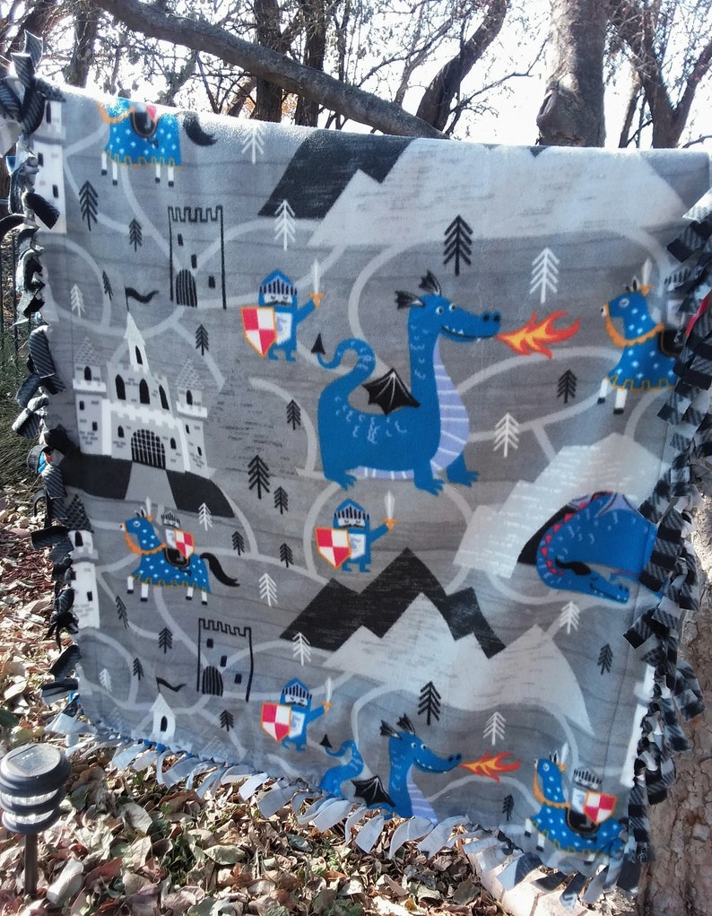 35W x 42L The design is fiery dragons with brave knights..What a fun throw!!! DragonsKnights Toddler Throw in 100/% polyester fleece