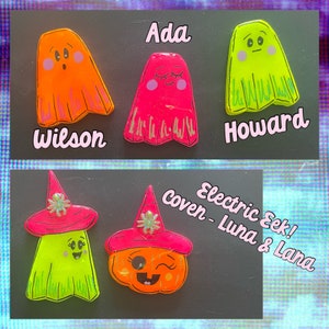 May include: Five colourful ghost and pumpkin Halloween ornaments with names written above them. The names are Ada, Wilson, Howard, Electric Seek! and Coven - Luna & Lana.