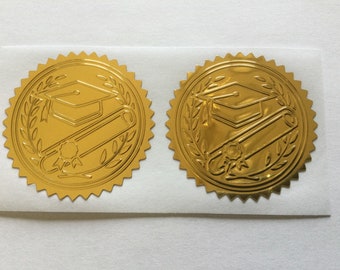 May include: Two gold foil graduation seals with a graduation cap and scroll design. The seals are on a white background.