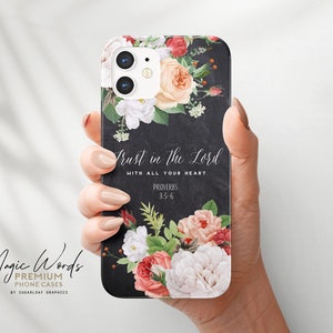 Könnte beinhalten: Eine schwarze Handyhülle mit floralem Design und dem Text "Trust in the Lord". Die Hülle hat einen Hintergrund in Tafeloptik mit einem Bouquet aus Rosen und anderen Blumen in Rosa-, Rot- und Weißtönen. Der Text "Proverbs 3:5-6" ist ebenfalls enthalten.