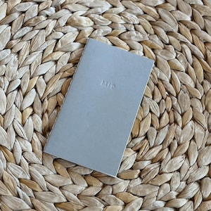Mini quaderno personalizzato con rilegatura a punto sella e stampa a rilievo. Libretto con testo in rilievo personalizzato (7,6 x 14 cm). Piccoli diari personalizzati con rilegatura a punto sella.