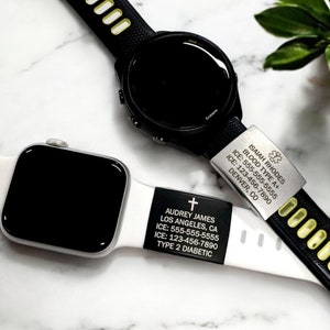 May include: Two smartwatches with black screens and medical ID tags. One watch has a black band with yellow accents and a silver tag with medical information. The other watch has a white band and a black tag with medical information.