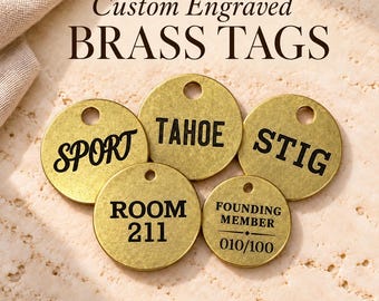 May include: Five circular brass tags with black engraved text. The tags feature the words SPORT, TAHOE, STIG, ROOM 211, and FOUNDING MEMBER 010/100. Each tag has a small hole at the top. The text Custom Engraved BRASS TAGS and 4 sizes 3 font options appear.