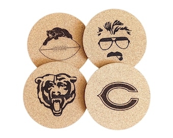 Puede incluir: Conjunto de cuatro posavasos de corcho con diseños grabados con láser. Los posavasos presentan un balón de fútbol, un oso, una cabeza de oso y un hombre con gafas de sol y bigote.