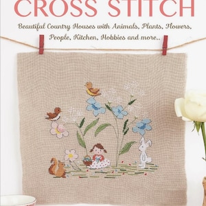 May include: A cross stitch pattern featuring a girl sitting in a field of flowers with a bunny, squirrel, and birds. The pattern is on a beige linen fabric and is titled "COUNTRYSIDE CROSS STITCH" with the text "Beautiful Country Houses with Animals, Plants, Flowers, People, Kitchen, Hobbies and more..." below the title. The pattern is by Lilli Violette and Tania Santarelli.