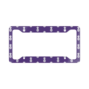 May include: Purple license plate frame with a white pineapple pattern.