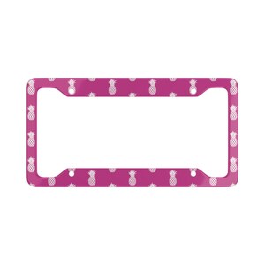May include: A pink license plate frame with a white pineapple pattern.