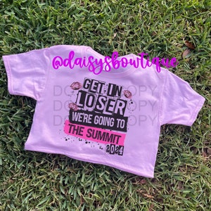 May include: Pink cropped t-shirt with black and white text that reads "Get in Loser We're Going to The Summit 2024". The text is surrounded by pink lips.