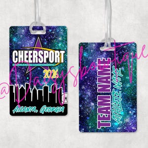 May include: Two rectangular luggage tags with a galaxy-themed background. One tag features the text "CHEERSPORT" with "CHEERLEADING CHAMPIONSHIPS 2026" and "ATLANTA, GEORGIA". The other tag says "TEAM NAME" and "ATHLETE NAME".