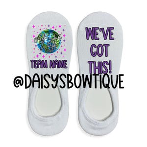 May include: A pair of white ankle socks with a purple and pink design. One sock says "All Star Worlds 2023" with a globe graphic and "Team Name". The other sock says "We've Got This!" @daisybowtique