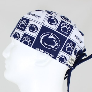 Peut inclure: Bonnet de chirurgien blanc et bleu marine avec un motif répété du logo Penn State et des empreintes de pattes. Le bonnet a une fermeture à nouer à l'arrière et les mots "PENN STATE" sont imprimés sur le bonnet.