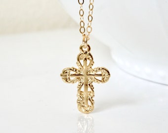 May include: A gold chain necklace with a delicate, ornate cross pendant.