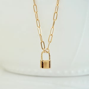 Op de afbeelding: Een gouden ketting met een klein gouden hangslotje.