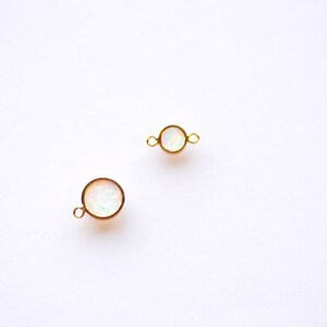 May include: Two gold-toned round connectors with white opal stones. Each connector has a loop on either side.