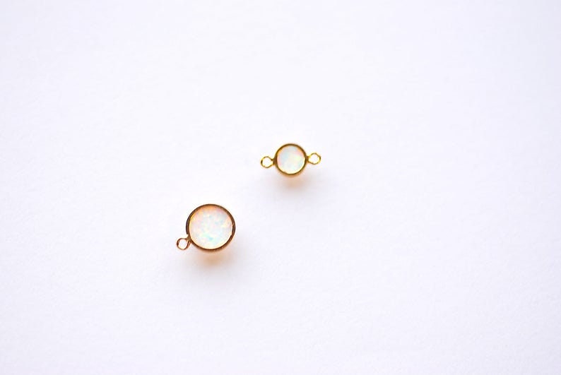 May include: Two gold-toned round connectors with white opal stones. Each connector has a loop on either side.