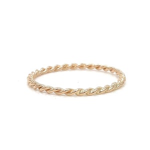 May include: A delicate gold-toned twisted band ring.