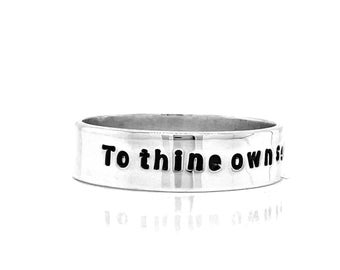 May include: A silver ring with the inscription "To thine own self be true" engraved on the band.