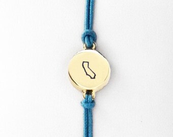 Pulseira com pingente do estado da Califórnia, em latão dourado, ajustável em macramê.