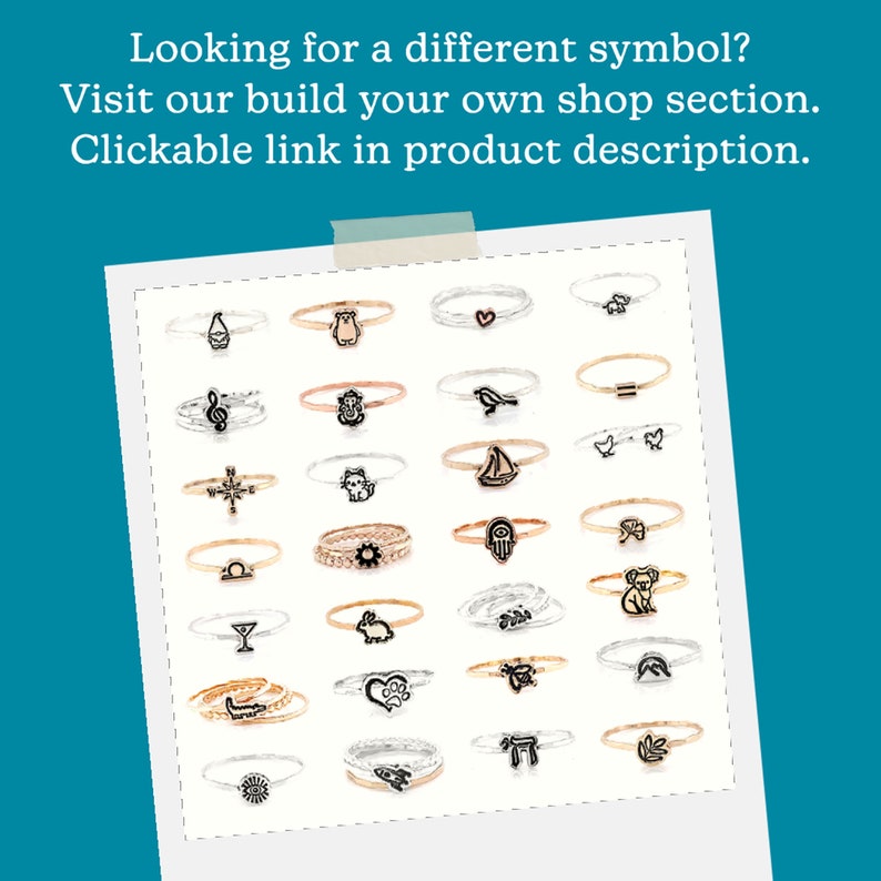 May include: A collection of 24 silver and gold rings with various symbols, including a heart, a bird, a sailboat, a cat, a compass, a hand, a koala, a martini glass, a rabbit, a paw print, a mountain, a menorah, and a leaf. The rings are displayed on a white background.