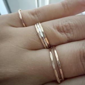 A customer showcasing our hammered stacking rings worn across multiple fingers, creating a bold and stylish statement that highlights the versatility of these handmade pieces.