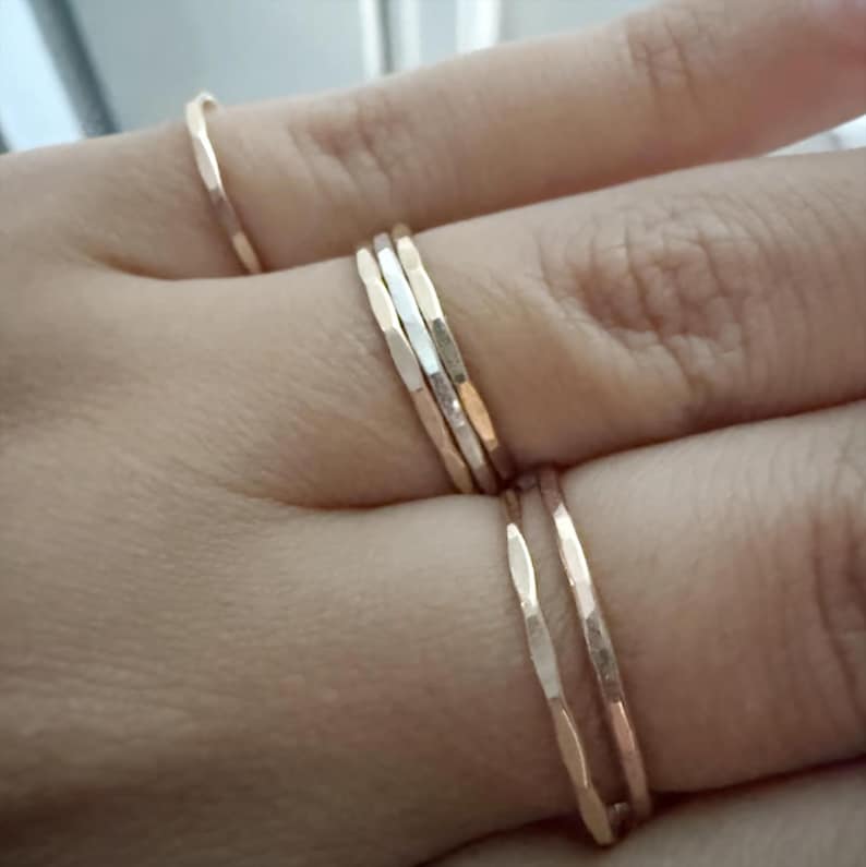 A customer showcasing our hammered stacking rings worn across multiple fingers, creating a bold and stylish statement that highlights the versatility of these handmade pieces.