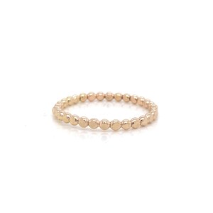 May include: A gold beaded ring with a simple design. The ring is made of small, round beads that are evenly spaced.