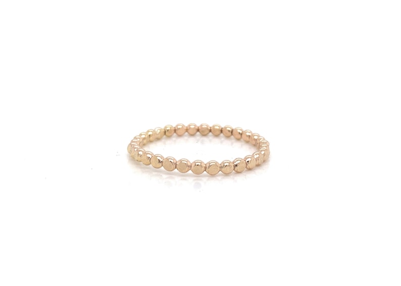 May include: A gold beaded ring with a simple design. The ring is made of small, round beads that are evenly spaced.