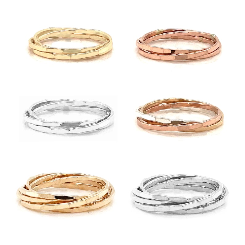 K&ouml;nnte beinhalten: Auswahl an ineinandergreifenden Ringen in Gold, Ros&eacute;gold und Silber. Jeder Ring hat eine strukturierte, geh&auml;mmerten Oberfl&auml;che. Die Ringe sind in verschiedenen Anordnungen angeordnet, um ihre Design- und Farbvariationen zu zeigen.