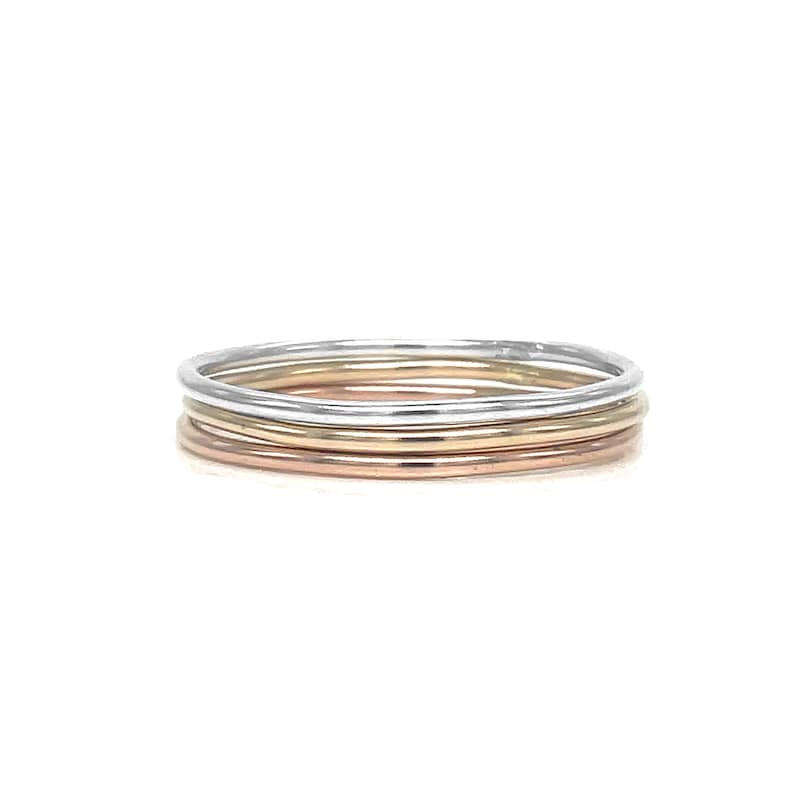 May include: Set of three thin stacking rings in silver, gold, and rose gold.