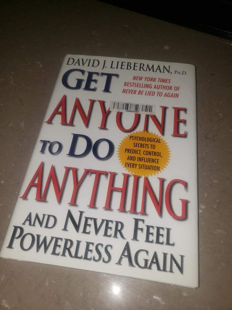 May include: A book titled "Get Anyone to Do Anything" by David J. Lieberman, Ph.D. The cover is white with bold blue and red text. It promises psychological secrets to predict, control, and influence every situation.