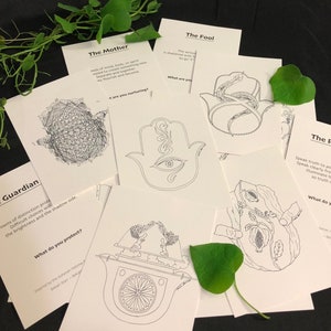 Può includere: Un set di 10 carte dei tarocchi con illustrazioni in bianco e nero. Le carte sono disposte su una superficie nera con foglie verdi. Le carte presentano immagini di una mano con un occhio, un serpente, un guardiano, una madre e uno sciocco. Le carte hanno del testo su di loro, tra cui "The Fool", "The Mother", "Guardian" e "The Path".