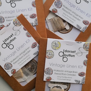 May include: Four brown paper envelopes with white card inserts. Each card features a vintage linen kit with a floral design and the text "dorset button Vintage Linen Kit Worked in vintage linen thread from Sweden Using the Blandford Crosswheel design".
